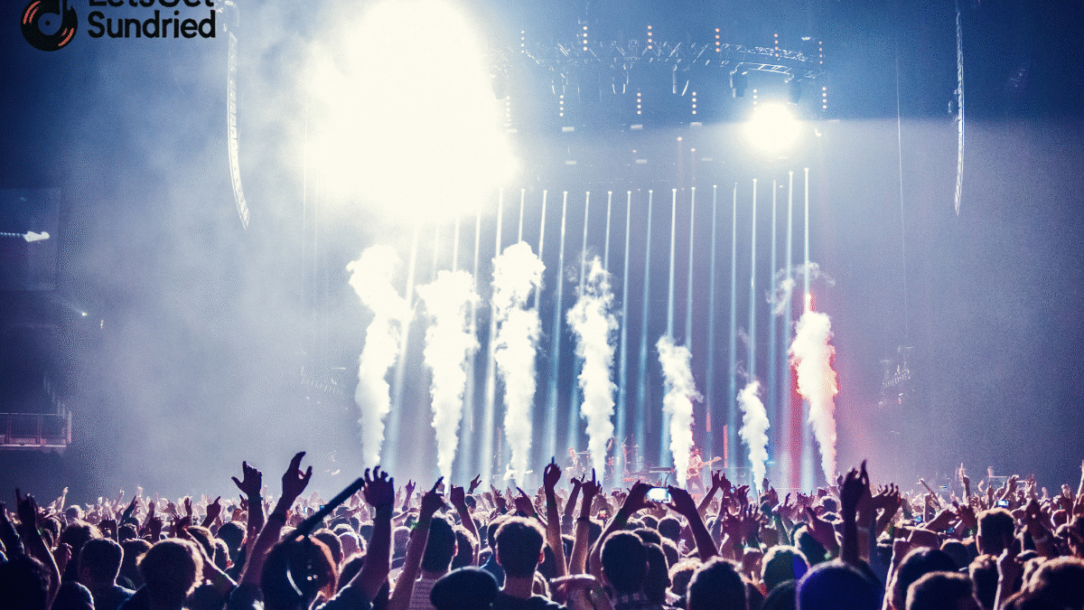 Suasana panggung konser EDM yang meriah dengan DJ dan kerumunan penonton. Ini membantu Anda mengenali genre EDM dari atmosfernya.