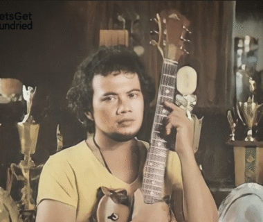 Seorang penyanyi dangdut koplo sedang bersemangat di atas panggung dengan mikrofon di tangan, merepresentasikan daya tarik dan energi dari rahasia lagu dangdut koplo.